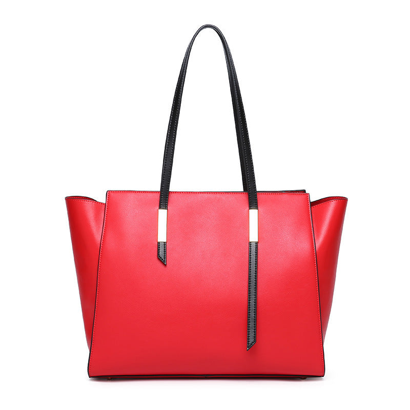Red handbag with black handles on a white background