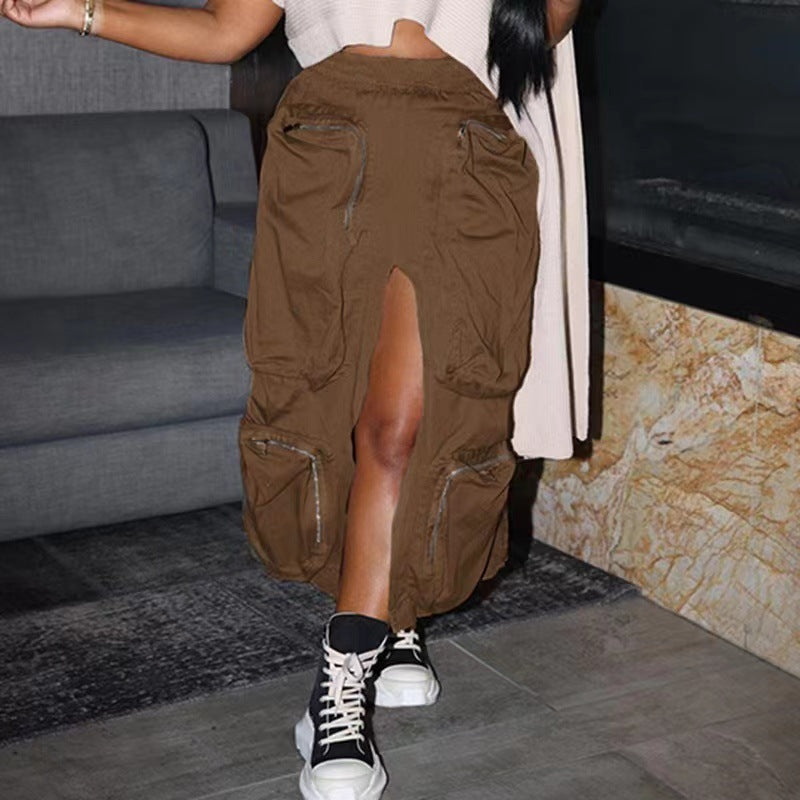 Person wearing brown cargo pants with a high slit, standing in a room with a gray couch and patterned wall.