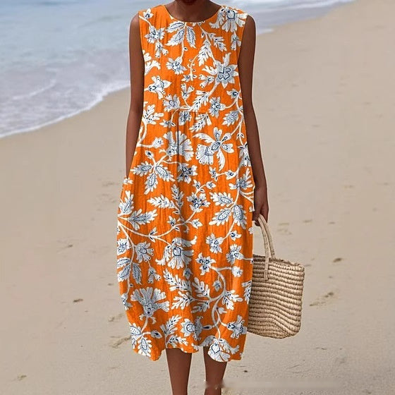 Woman wearing an orange floral dress on a beach