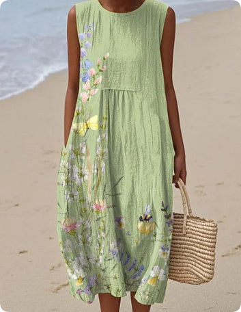 Person wearing a green floral dress on a beach