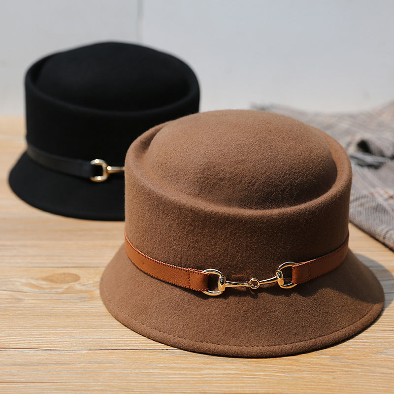 Brown felt hat with a leather band on a wooden surface