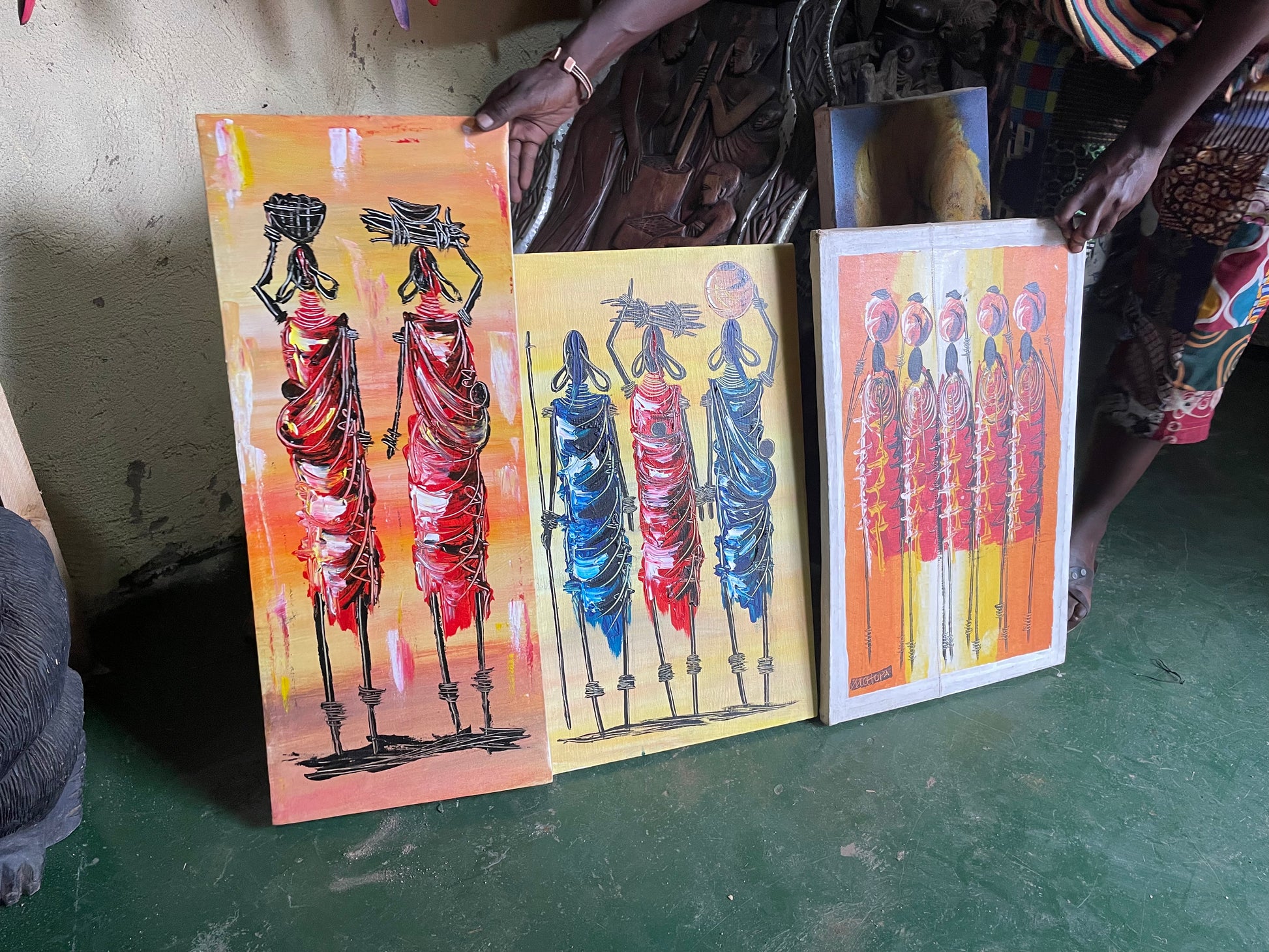 multiple paintings of traditional rwandan art paintings of african women holding community tools